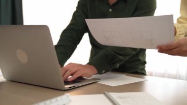 Mimar ve mühendis, modern ofisteki tablo üzerinde tasarım, ölçüm aracı ve plan için dizüstü bilgisayardaki taslak ayrıntılı taslak ile el yazısını karşılaştırıyor. - Yakın çekim. Tanımlama.