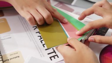 Grafik tasarımı için renk seçimi yapan ve beyin fırtınası yapan iki tasarımcının yavaş çekim çekimi ya da tasarım bürosunda kromatik danışmanlık hizmeti isteyen bir müşteri. Değiştirilmiş