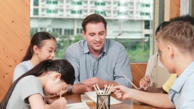 Sıradan tişörtlü zeki liseli çocuk, karışık ırkları olan öğrenciler kitap yazarken profesyonel öğretmene soruyor. Yaratıcı çocuk notayı işaret ederken Kafkas eğitmeni yorum yapıyor. Öğretim