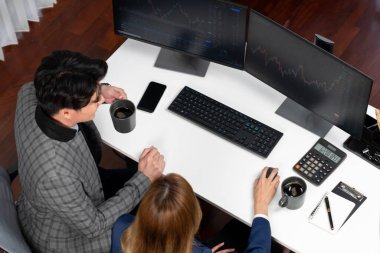 Başarılı Asyalı iş kadınının iş ortağı ile iş ortağı arasındaki dinamik borsa veri ekranına bakarak internet sitesi programını analiz etmenin en iyi görüntüsü. İnfobahn.