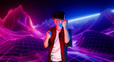 VR kulaklık takan ve soyut arka planda duran sıradan giysili bir adam video oyunu oynuyor. Zeki Asyalı oyuncu oyunu kazanmak için artırılmış gerçeklik teknolojisini kullanıyor. Yaratıcılık.