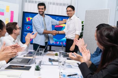 Analist ekip lideri, iş zekası ya da BI gösterge paneli ile FIntech yazılım gücünü kullanarak başarılı veri analizi toplantısından sonra iş arkadaşıyla tokalaştı. Tedbirli