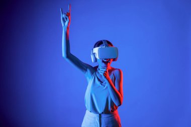 Zeki bir kadın, metaevreni birbirine bağlayan VR kulaklık takan neon ışıklarla çevrili duruyor. Gelecekteki siber uzay topluluğu teknolojisi. Zarif bir kadın dans etmekten, dans etmekten ve şarkı söylemekten hoşlanır. Halüsinasyon.