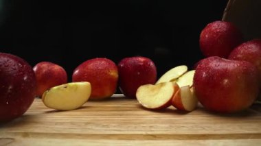 Makrografi, taze elma dilimleri çarpıcı bir siyah arka plana karşı bir kesme tahtasına yerleştirilmiştir. Her yakın çekim elmaların canlı dokusunu ve canlı renklerini yakalar. Geliştirilebilir.