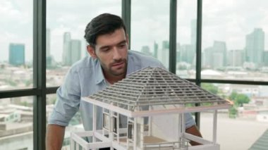 Modern ofiste gökdelen ve şehir manzaralı kalem ölçme modeli çatı uzunluğu kullanan profesyonel mimar mühendisi. Yetenekli proje yöneticisi ya da işadamı ev inşaatını kontrol ediyor. İzleme