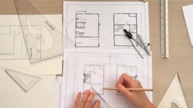 Akıllı mimar ya da akıllı mühendisin ölçüm aracı ve kalem el kullanarak mimari ofisindeki inşaat isabet planı üzerine detaylı bir yazı yazışının videosu. Eline odaklan. - Yakın çekim. Tanımlama.