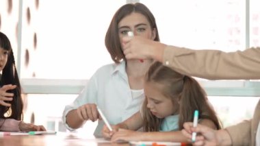 Çizim kitabında işaret kullanarak çeşitli öğrencilerin ve zeki öğretmen çizimlerinin panorama çekimi. Sanat dersinde çizim kitabını kullanarak çok kültürlü bir öğrenci. Rahatlama. Etkinlik.