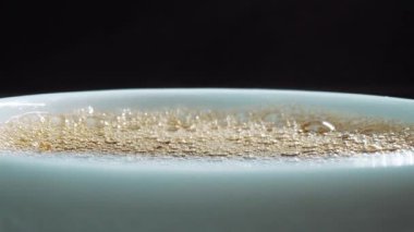 Aromatik sıcak kahve köpüğünü siyah arka planda fincana yaklaştır. Sıcak kahve ya da espresso beyaz kahve bardağına dökülüyor ve kaynamış suya dökülüyor. Geliştirilebilir.