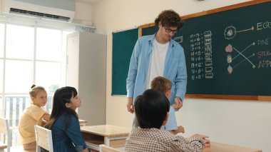 Kafkas öğretmeni matematik dersinde tahtaya cevap yazmak için gönüllü buldu. Öğretmen, öğrenciye tebeşir verilirken ve sınıfın önünde yürürken soruyu cevaplamak için gönüllü olmayı talep ediyor. Pedagoji.