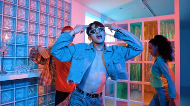 Değişik takımlarla dans ederken süslü gözlük takan yakışıklı hippi serbest stil müzikle mutlulukla dans ediyor. Beyaz hipster kulüpte parlak neon ışıkta sokak dansı yapıyor. Mutluluk.