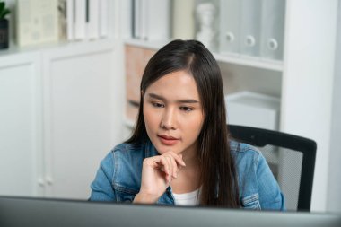 Genç ve güzel Asyalı yaratıcı yönetici bilgisayar üzerinde çalışıyor, yeni bir web sitesi tasarımı ile yeni sosyal medya çevrimiçi kanal planlaması üzerinde modern ev ofisinde kot pantolon gömleği ile çalışıyor. Taktik.