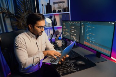 Akıllı IT geliştiricisi, yazılım kodlama sisteminde Neon Light ofis odasında yazı yazmak için çalışıyor, uygulama programı güncellemesi en son online web sitesi veritabanını çevrimiçi yapıyor. Tahmin et..