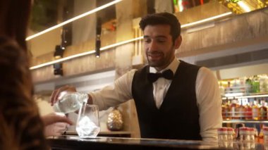 Lüks barlarda cin kokteyli ya da tonik servisi yapan akıllı barmenlere odaklanırken, arka plandaki VIP müşterilerle sıcak gece kulübünün ışıklandırma atmosferinde canlı sohbetler yapıyorlar. Vinosity.