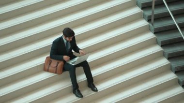 Üst düzey bir iş adamı merdivenlerde otururken başarılı bir projeyi kutluyor. Proje yöneticisi yeni bir pozisyon alıyor, terfi alıyor, arkadaşlarını ararken dizüstü bilgisayar kullanarak satışları artıyor. Sevinçli..