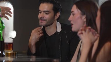 Duman çıkaran dumanlı bir barmen kokteyl sunumuyla viskiyi karıştırıyor. Grup misafirlerine içki tezgahında özel hoş geldin içkisi öneriyor. Vinosity.