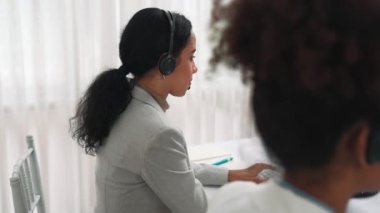 Ofiste çalışan kulaklık takan işadamları uzak müşteri ya da meslektaşlarını desteklemek için çalışıyorlar. Çağrı merkezi, tele pazarlama, müşteri destek acentesi telefon görüntülü konferans görüşmesi için hayati önem taşıyor.