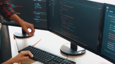 Yavaş çekimde geri uç veya yazılım geliştirici yöneticisi ekibini monitörde hata ayıklama ve karmaşık kod algoritmalarını çözmede yeni uygulama programı geliştirmede denetliyor. Filizlenen
