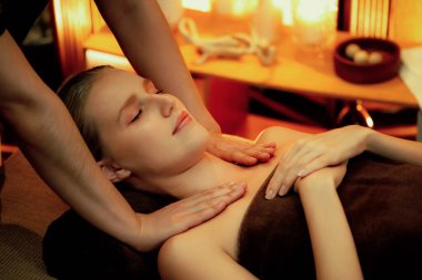 Beyaz kadın müşteri stres önleyici spa masajının keyfini çıkarıyor ve lüks otel ya da otelde sıcak mum ışığında güzellik teniyle eğleniyor. Sessiz.