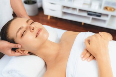 Kafkasyalı kadın stres önleyici kafa masajından ve lüks tatil beldesi ya da otel spa salonundaki modern ışık ortamında yüz güzelliği eğlencelerini şımartmaktan hoşlanıyor. Sessiz.