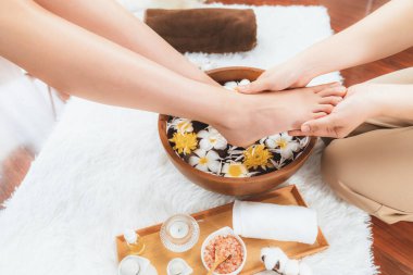 Kadınlar lüks spa salonlarında keyifli ayak masajlarına devam ederken, masör de hafif gün ışığı atmosferinde refleksoloji terapisi veya otel ayak spa 'sında. Sessiz.