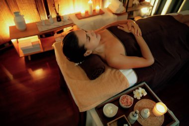 Beyaz kadın müşteri stres önleyici spa masajının keyfini çıkarıyor ve lüks otel ya da otelde sıcak mum ışığında güzellik teniyle eğleniyor. Sessiz.