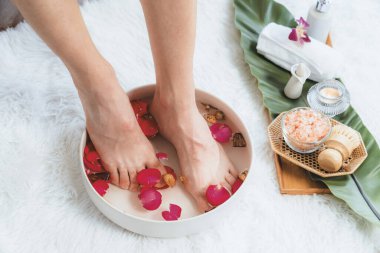 Kadınlar lüks spa salonlarında keyifli ayak masajlarına devam ederken, masör de hafif gün ışığı atmosferinde refleksoloji terapisi veya otel ayak spa 'sında. Sessiz.