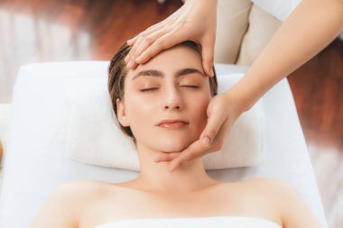 Kafkasyalı kadın stres önleyici kafa masajından ve lüks tatil beldesi ya da otel spa salonundaki modern ışık ortamında yüz güzelliği eğlencelerini şımartmaktan hoşlanıyor. Sessiz.