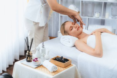 Kafkasyalı kadın stres önleyici kafa masajından ve lüks tatil beldesi ya da otel spa salonundaki modern ışık ortamında yüz güzelliği eğlencelerini şımartmaktan hoşlanıyor. Sessiz.