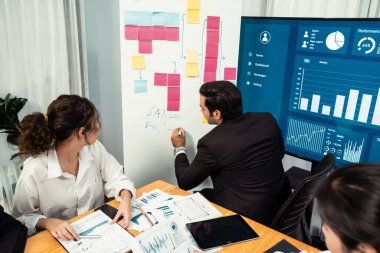 Finansal veri raporunu analiz eden çeşitli bir grup iş analisti. Mali veri analiz çizelgesi ve grafik paneli stratejik pazarlama planlama için toplantı odasında TV ekranında. Habiliment