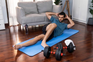 Atletik ve sporcu adam, evde vücut egzersizi yaparken spor ve spor yaşam tarzına uyum sağlamak için spor minderinde çatırdıyor. Gaiety ev egzersizi antrenman konsepti.