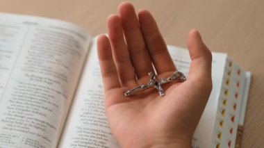 Hristiyan katolik takipçilerle dinsel bağlılık ve maneviyat duygusu doludur. Ağır çekimde el, kutsal İncil 'i nazikçe tutar ve dini dua ve Hıristiyanlık eğitimi için çaprazlar. Filizlenen