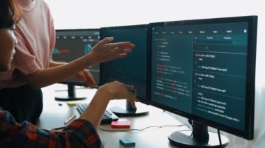Yavaş çekim arkası yazılım geliştirici mühendisi bilgisayar programlama için birlikte çalışarak hata ayıklama kodunu çözüyor, ofiste monitörde karmaşık algoritmaları çözüyor. Filizlenen
