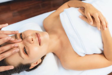 Kafkasyalı kadın stres önleyici kafa masajından ve lüks tatil beldesi ya da otel spa salonundaki modern ışık ortamında yüz güzelliği eğlencelerini şımartmaktan hoşlanıyor. Sessiz.