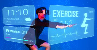 Sanal gerçeklik gözlüğü takan Asyalı bir adam holograma ve egzersize bakıyor. Mavi arka planda kalan ya da yapay zeka kullanan erkek model. Teknoloji yeniliği konsepti. Yaratıcılık.