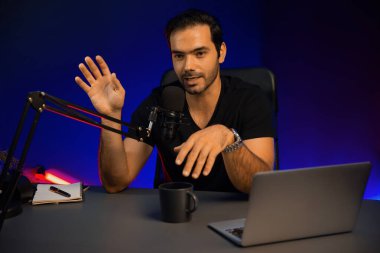 Yayıncı, fanclub dinleyicisiyle mikrofon kullanarak konuşuyor. Mor neon ışıklı modern stüdyoda yaratıcı olumlu düşünce konseptiyle canlı yayında finansal sorunları tartışıyor. Tahmin et..