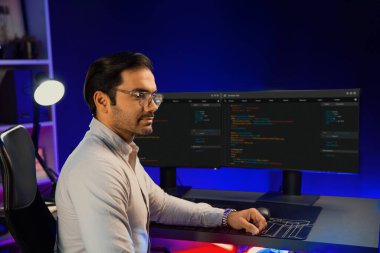 Bilgisayar ekranında çalışan akıllı bilişim geliştirici yazılım geliştirme kodlaması. Arka tarafa bakan, program güncellemesi düşünen, neon ışıklı siber ofis online web sitesi verileri. Tahmin et..