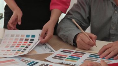 Grafik tasarımı için beyin fırtınası yapan ve renk seçimi yapan tasarımcı ekibinin yavaş çekim çekimi veya tasarım bürosunda krom danışmanlığı için danışmanlık isteyen bir müşteri. Değiştirilmiş