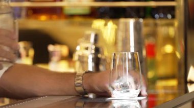 Yakından bir barmen, taze gazlı gazlı dokuları bir bardak içeceğe dönüştürerek müşterilere içecek tezgahı lüks barında hoş geldin tebrikleri sunuyor. Vinosity.