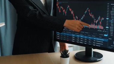 Menkul kıymetler borsası pazarlamasını inceleyen borsa yatırımcıları, zarar ve kazanç için mum bar fiyatlarını analiz eden monitörlere bakıyor. Filizlenen