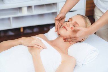 Kafkasyalı kadın stres önleyici kafa masajından ve lüks tatil beldesi ya da otel spa salonundaki modern ışık ortamında yüz güzelliği eğlencelerini şımartmaktan hoşlanıyor. Sessiz.