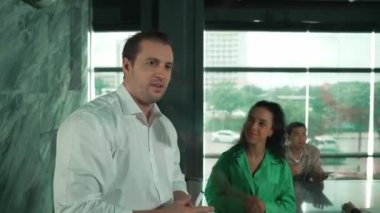 Yetenekli işadamı, cam duvara renkli yapışkan notlar yapıştırarak proje yöneticisine pazarlama fikrini sundu. Proje yöneticisi yatırımcıya projeyi gösteriyor, anlatıyor, gösteriyor. Yönlendirici.