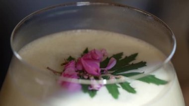 Kapalı tutku meyveleri ve üzerine pembe çiçek eklenerek süslenmiş tatlı likör kokteyli, alkol serinletici vitrin odaklı reklamı için özel yaratıcı içecek menüsü listesi oluşturuyor. Vinosity.