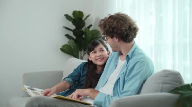 Beyaz bir baba ve tatlı bir kız kanepede otururken masal kitabı okuyorlar. Mutlu bir baba, sevimli bir Amerikan çocuğuna, birlikte zaman geçirirken hayal gücünün gelişmesi için hikaye anlatıyor. Pedagoji.