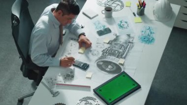 Mühendisin, toplantı masasındaki türbin motorunu ekipmanla gösteren üst düzey görüntüsü. Profesyonel proje yöneticisinin elektronik jeneratör sistemi hakkında konuştuğu ve tartıştığı hava görüntüsü. Hizalama.