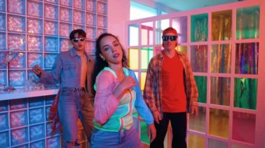 Genç İspanyol dansçı gece kulübünde dans ederken kameraya bakıyor. Serbest stil müzik eşliğinde dans eden profesyonel sanatçı çok kültürlü hipster ya da çeşitli arkadaşlar tarafından destekleniyor. Mutluluk.