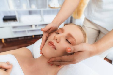 Kafkasyalı kadın stres önleyici kafa masajından ve lüks tatil beldesi ya da otel spa salonundaki modern ışık ortamında yüz güzelliği eğlencelerini şımartmaktan hoşlanıyor. Sessiz.