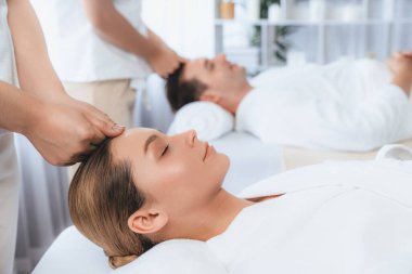 Kafkasyalı çift stres önleyici kafa masajının keyfini çıkarıyor ve lüks otellerde ya da otel spa salonlarında gündüz kaplıcalarında yüz güzelliği eğlencelerini şımartıyor. Sessiz.