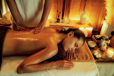 Beyaz kadın müşteri stres önleyici spa masajının keyfini çıkarıyor ve lüks otel ya da otelde sıcak mum ışığında güzellik teniyle eğleniyor. Sessiz.
