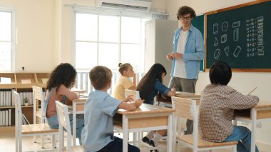 Öğrenci ödevlerine bakarken sınıfta yürüyen yetenekli bir öğretmen. Sınav yaparken ya da sınıfta ödev yaparken akıllı çocuk defterini kontrol eden profesyonel bir eğitmen. Pedagoji.