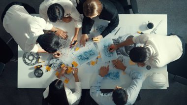 Türbin motoru tasarlamak için çalışan akıllı mühendis takımının yukarıdan aşağıya hava görüntüsü. Profesyonel teknisyen jet motoru yapımını tartışırken motorun bir kısmını işaret ediyor. Hizalama.